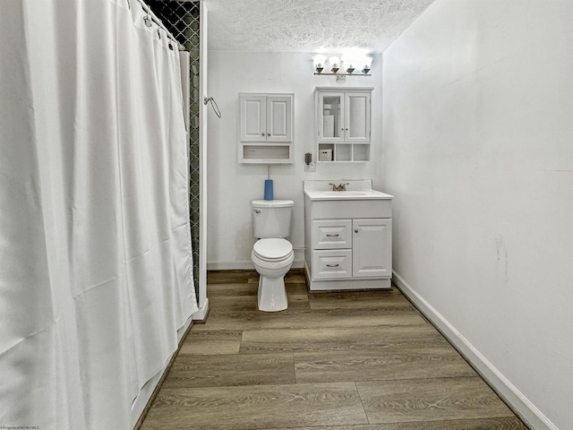 bathroom with vanity, a shower with shower curtain, toilet, a textured ceiling, and wood-type flooring