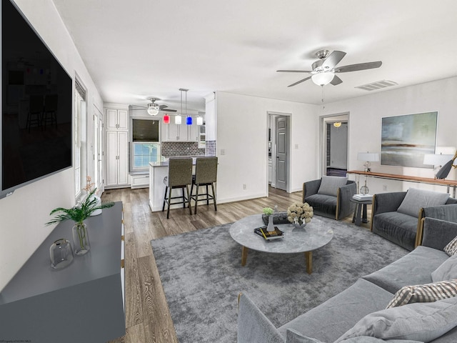 living room featuring hardwood / wood-style flooring and ceiling fan