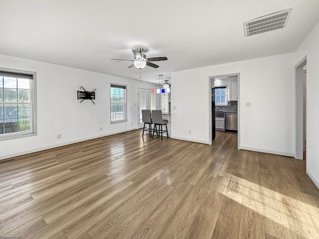 unfurnished living room with ceiling fan and hardwood / wood-style floors