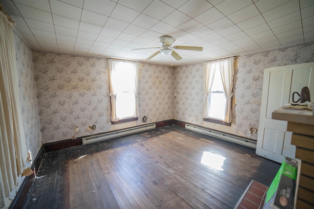 unfurnished room with dark hardwood / wood-style floors, ceiling fan, and a baseboard heating unit