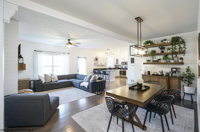 dining room featuring a textured ceiling, ceiling fan, and dark wood-type flooring