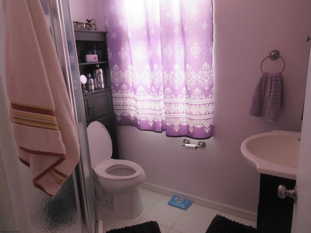 bathroom with toilet, vanity, and tile patterned floors