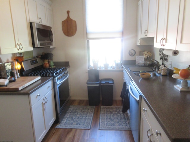 kitchen with white cabinets, dark hardwood / wood-style flooring, sink, and appliances with stainless steel finishes