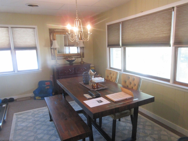 dining area with carpet flooring and a chandelier