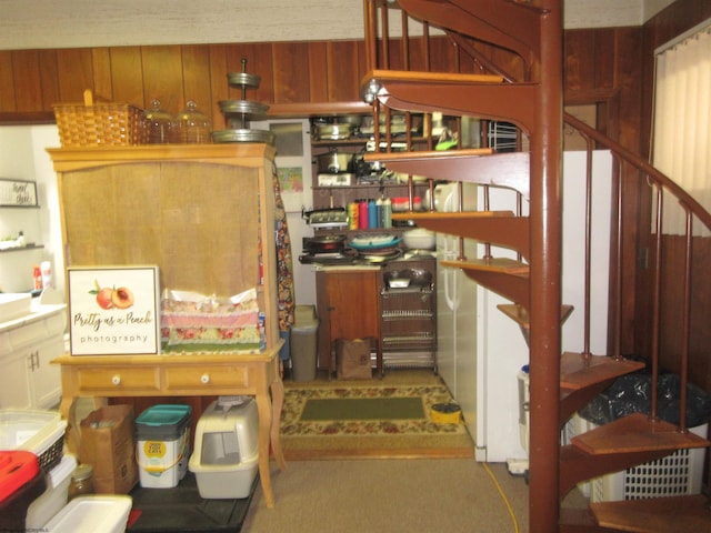 stairway featuring carpet flooring and wooden walls