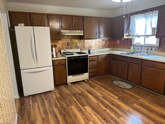 kitchen featuring decorative backsplash, white appliances, sink, and dark wood-type flooring