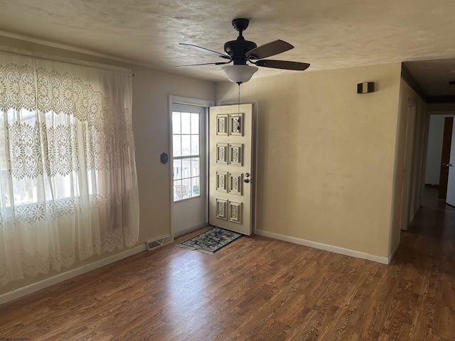 doorway with hardwood / wood-style floors, a textured ceiling, and ceiling fan