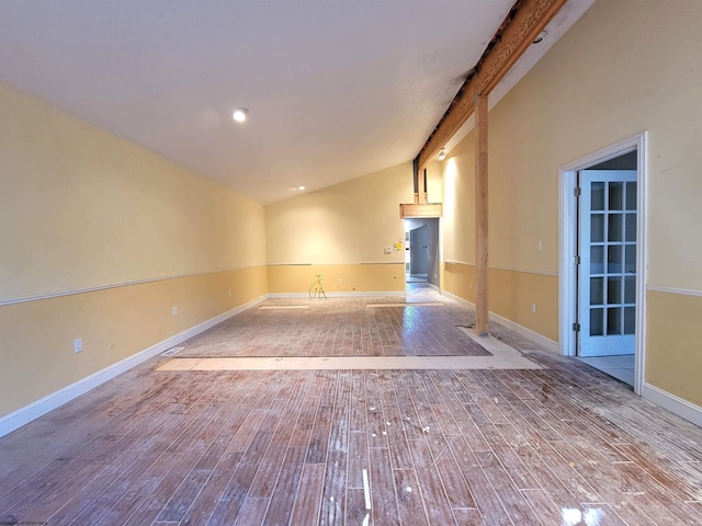 spare room with vaulted ceiling with beams and light hardwood / wood-style floors