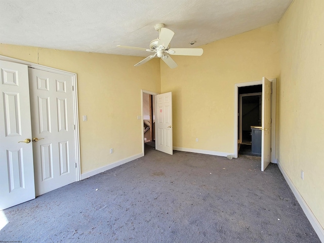 unfurnished bedroom with lofted ceiling, carpet flooring, ceiling fan, a textured ceiling, and a closet