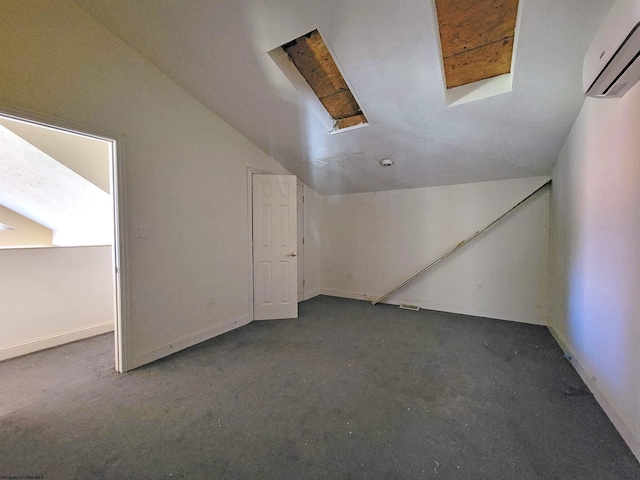 bonus room featuring dark carpet, a wall unit AC, and vaulted ceiling