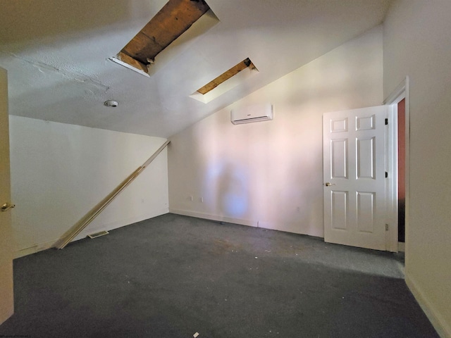 interior space featuring a wall unit AC, dark carpet, and lofted ceiling