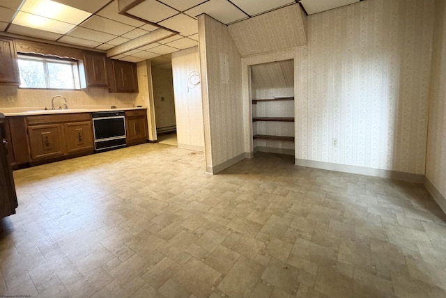 kitchen with a paneled ceiling, sink, and black dishwasher