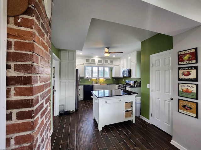 kitchen with white cabinets, ceiling fan, appliances with stainless steel finishes, dark hardwood / wood-style flooring, and kitchen peninsula