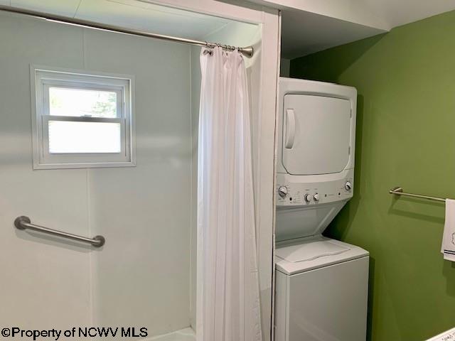 laundry room with stacked washing maching and dryer