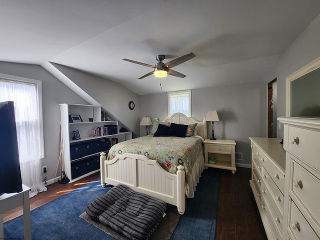 bedroom with ceiling fan, dark wood-type flooring, and vaulted ceiling