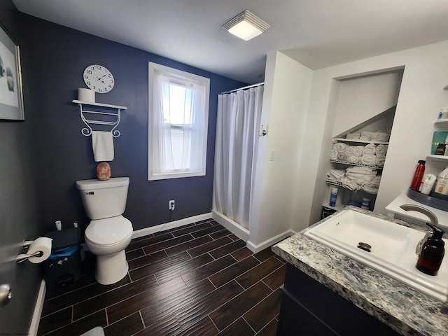 bathroom featuring vanity, toilet, wood-type flooring, and walk in shower