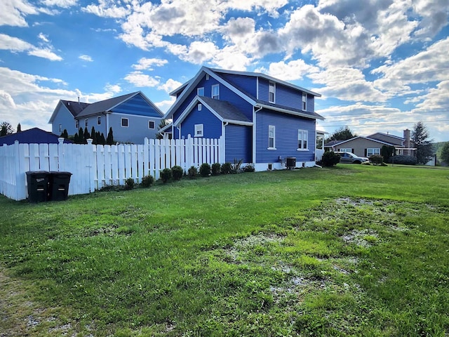 rear view of property with central air condition unit and a lawn