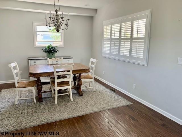 dining space with hardwood / wood-style flooring and a notable chandelier