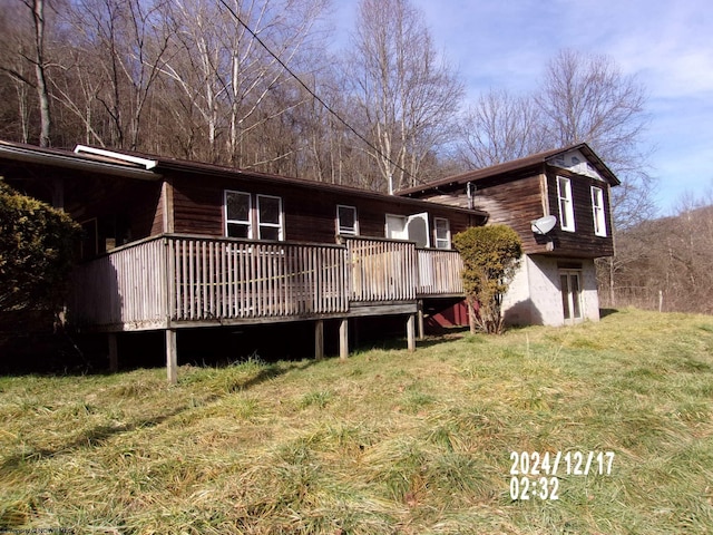 back of property featuring a lawn and a deck