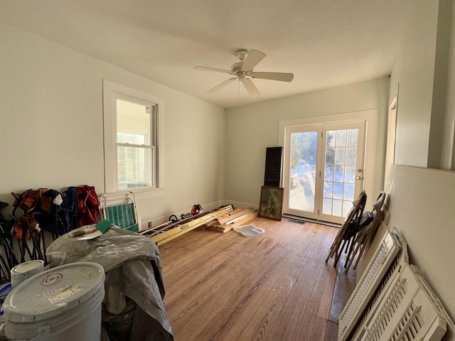 interior space with multiple windows, ceiling fan, hardwood / wood-style flooring, and access to exterior