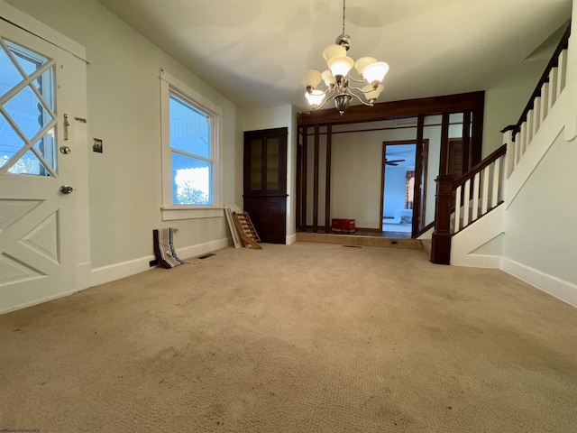 entrance foyer featuring a notable chandelier and carpet floors