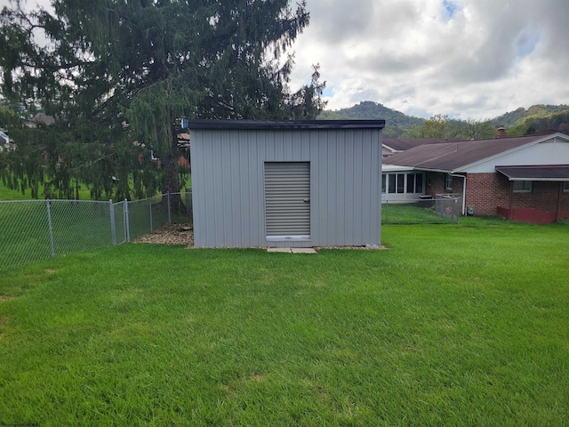 view of outdoor structure with a mountain view and a yard