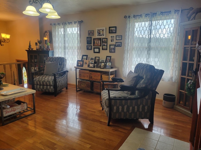 living area featuring hardwood / wood-style floors and an inviting chandelier