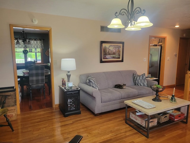 living room featuring hardwood / wood-style floors and an inviting chandelier