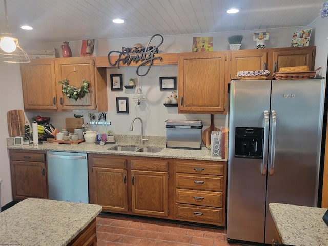 kitchen with light stone counters, sink, and appliances with stainless steel finishes