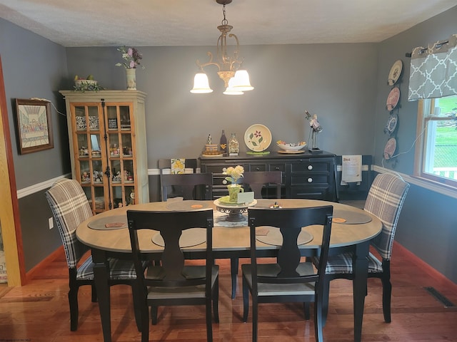 dining area featuring a chandelier, a textured ceiling, and hardwood / wood-style flooring