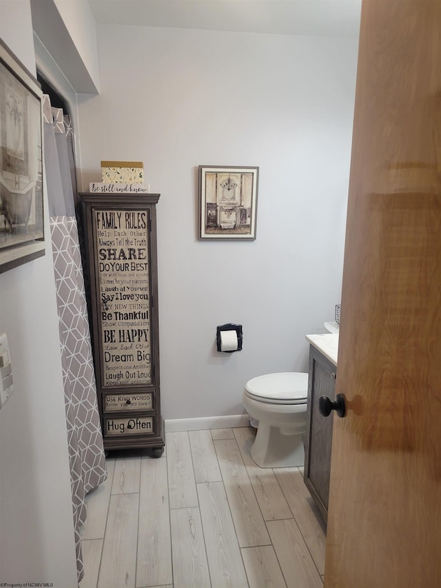 bathroom with vanity, wood-type flooring, and toilet