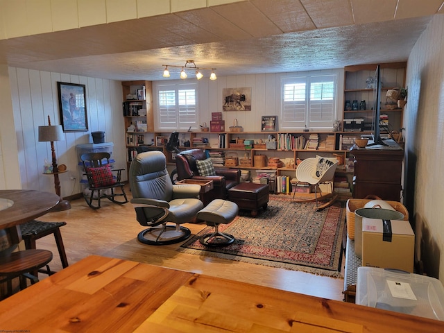 sitting room with plenty of natural light, wood-type flooring, and a textured ceiling