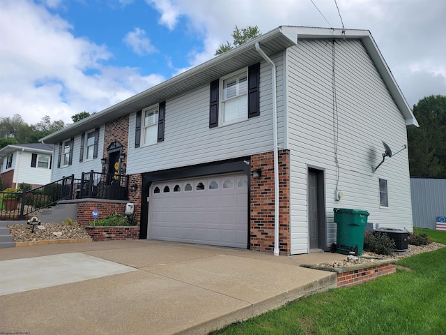 raised ranch with central AC unit and a garage