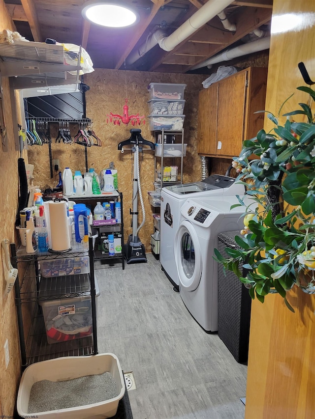 laundry room with cabinets, light hardwood / wood-style flooring, and washing machine and clothes dryer