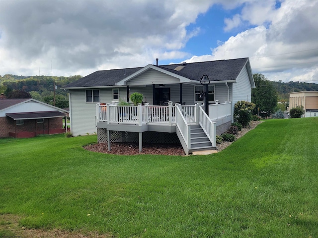 rear view of house featuring a yard and a deck