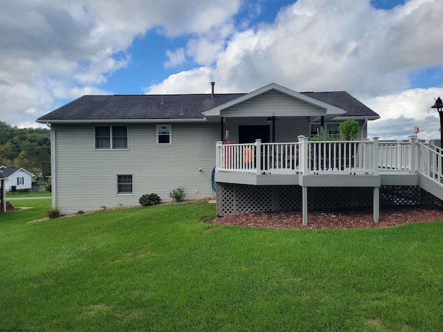 back of property featuring a lawn, ceiling fan, and a deck