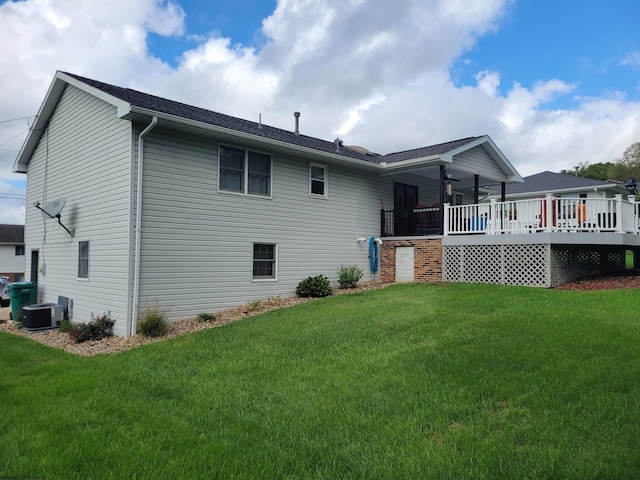 back of house with ceiling fan, central air condition unit, a lawn, and a wooden deck