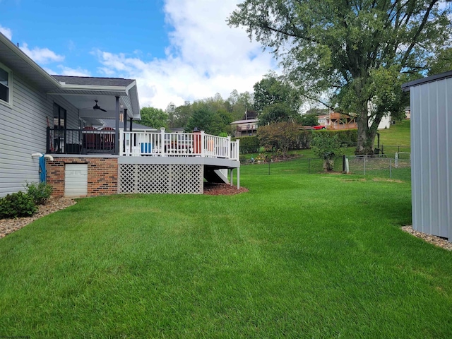 view of yard with ceiling fan and a wooden deck