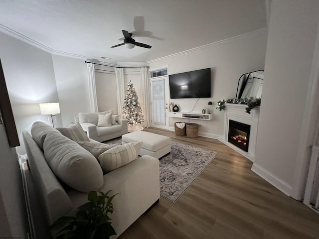 living room with radiator heating unit, dark hardwood / wood-style floors, ceiling fan, and ornamental molding