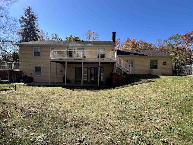 back of house featuring a lawn and a deck