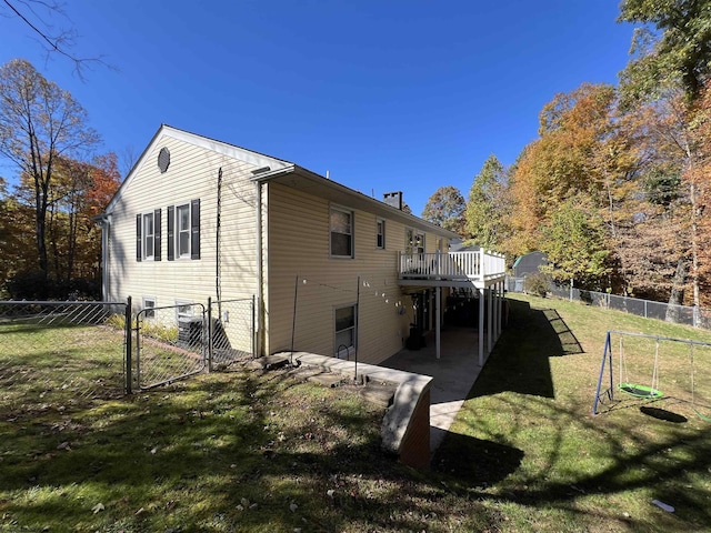 view of side of property with a lawn, a patio area, and a deck