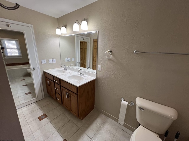 bathroom with tile patterned flooring, vanity, a bath, and toilet