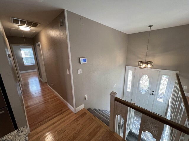 entrance foyer with hardwood / wood-style floors and a notable chandelier