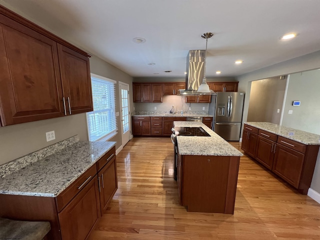 kitchen featuring pendant lighting, stainless steel refrigerator with ice dispenser, a kitchen island, light hardwood / wood-style floors, and island range hood