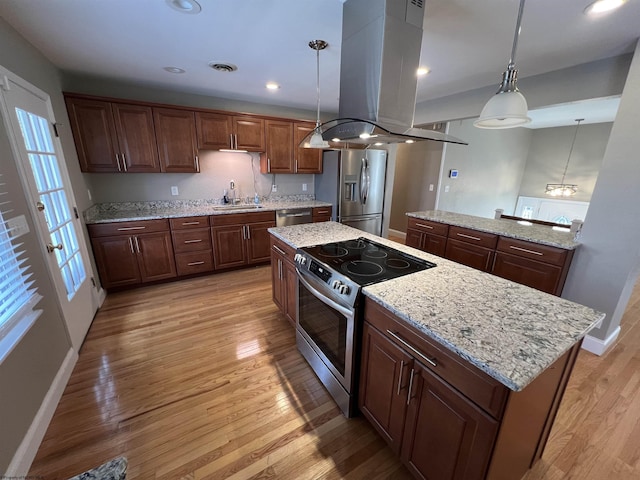 kitchen with pendant lighting, a center island, light hardwood / wood-style flooring, appliances with stainless steel finishes, and island exhaust hood