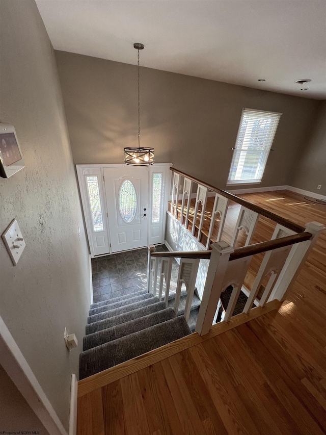 entrance foyer featuring plenty of natural light, a chandelier, and dark hardwood / wood-style floors