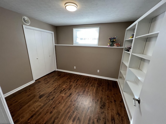 unfurnished bedroom featuring a closet, dark wood-type flooring, and a textured ceiling