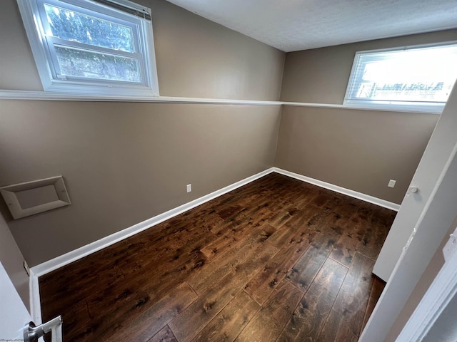 empty room featuring a textured ceiling and dark hardwood / wood-style floors