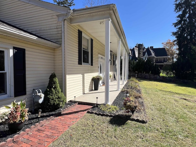 view of property exterior featuring a lawn and covered porch