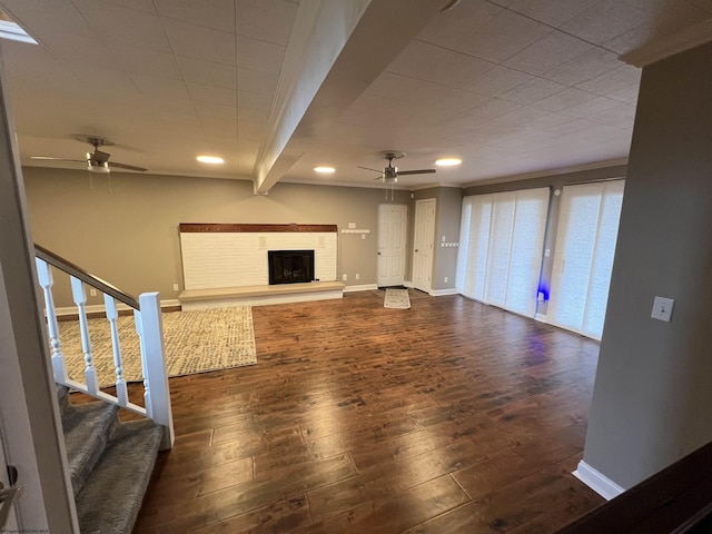 unfurnished living room featuring ceiling fan, crown molding, beamed ceiling, and dark hardwood / wood-style floors